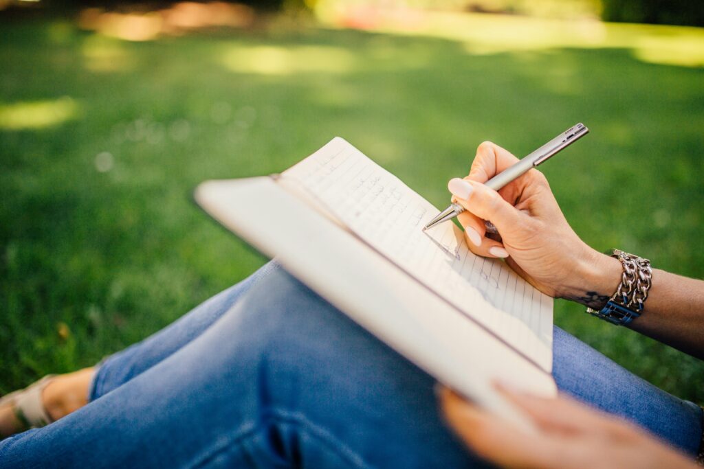 Woman journaling in a park on a sunny day 