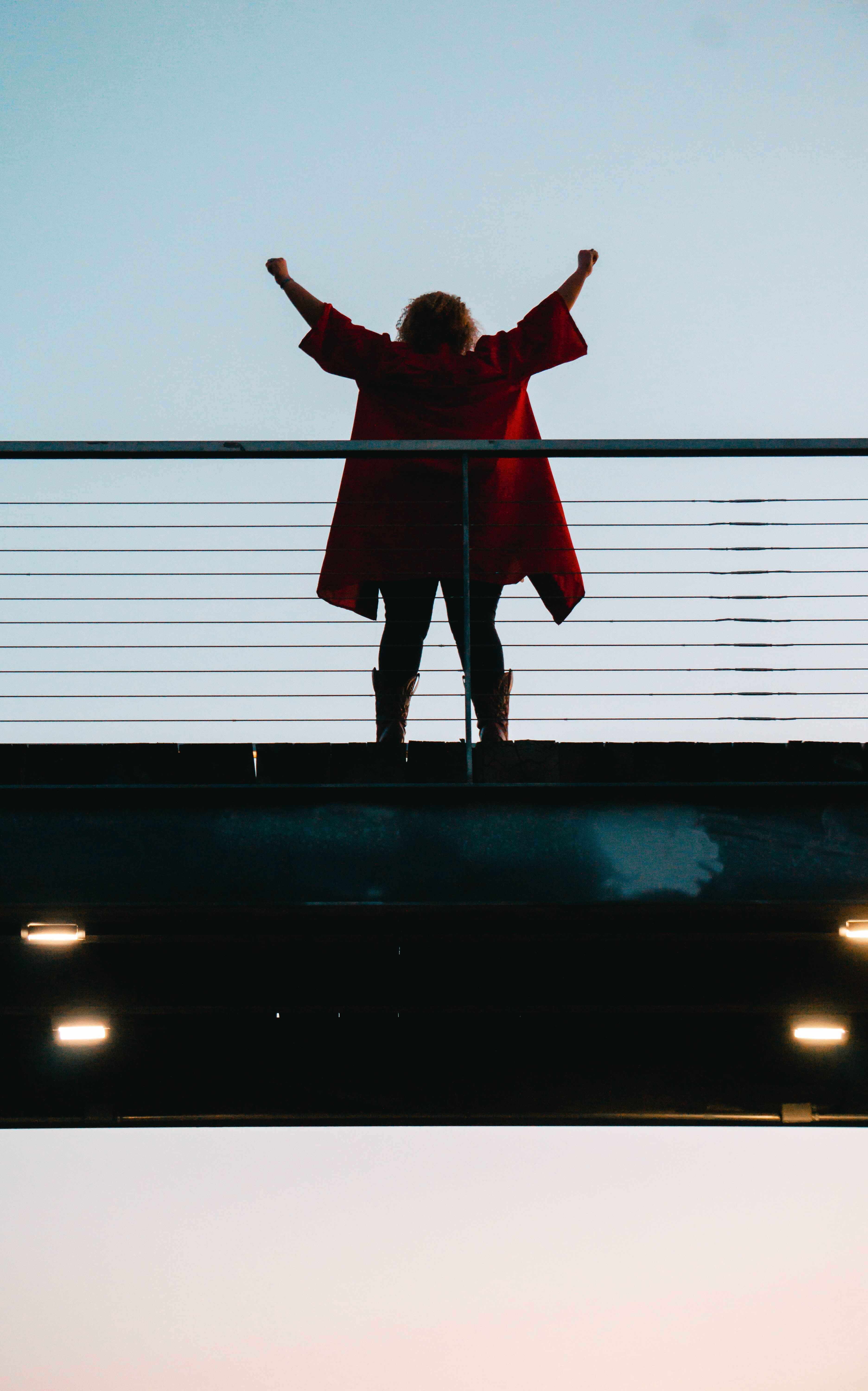 Woman doing a victory stance on a bridge 